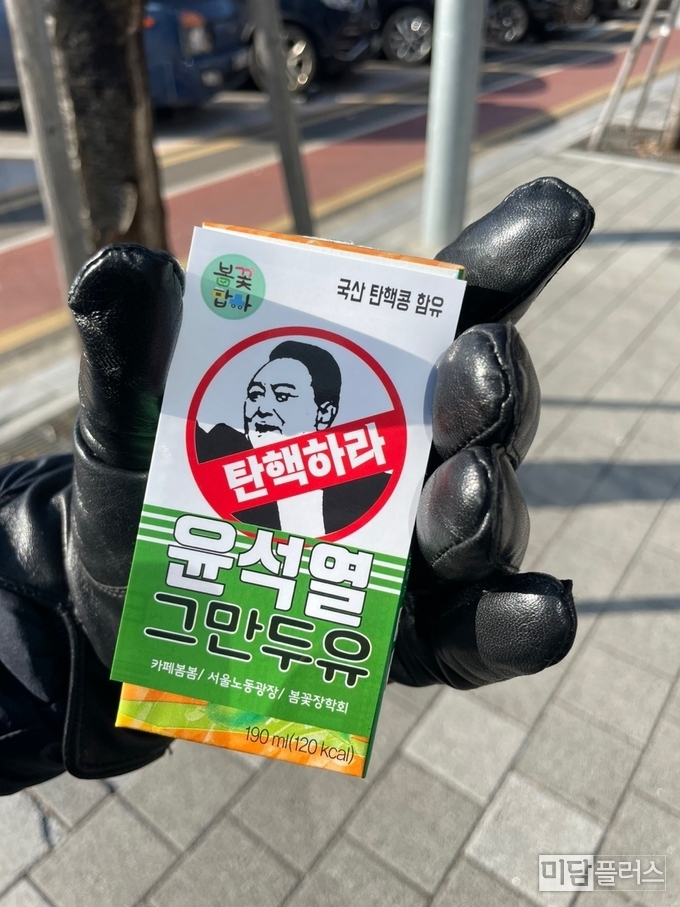 집회에 참석한 참여자가 '윤석열 그만두유' 음료를 들고 있다. ( 사진 -집회 참여자 제공) 