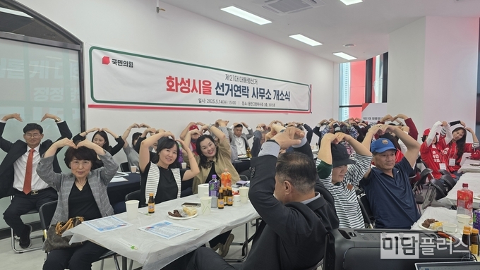 국민의힘 화성 을 선거연락사무소 개소식에 지지자들이 손하트를 표하며 사진 촬영을 하고 있다. 제일 좌측 신영락 당협위원장 